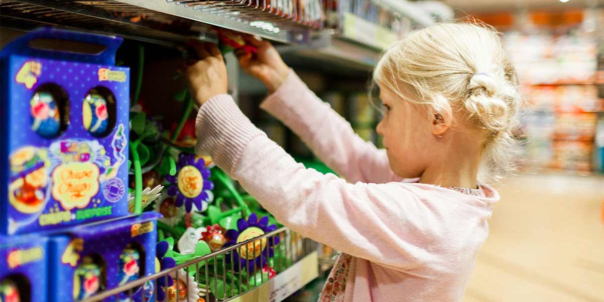 Kleines Mädchen sucht sich ein Spielzeug im Laden aus