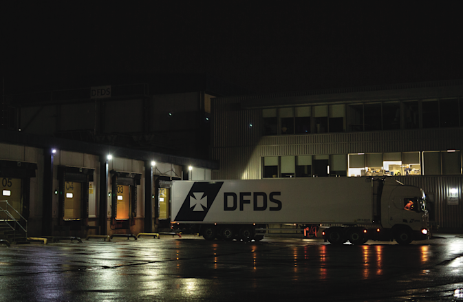 A DFDS Logistics truck leaving the terminal at night