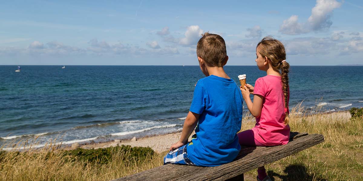 Barn på strand spiser is