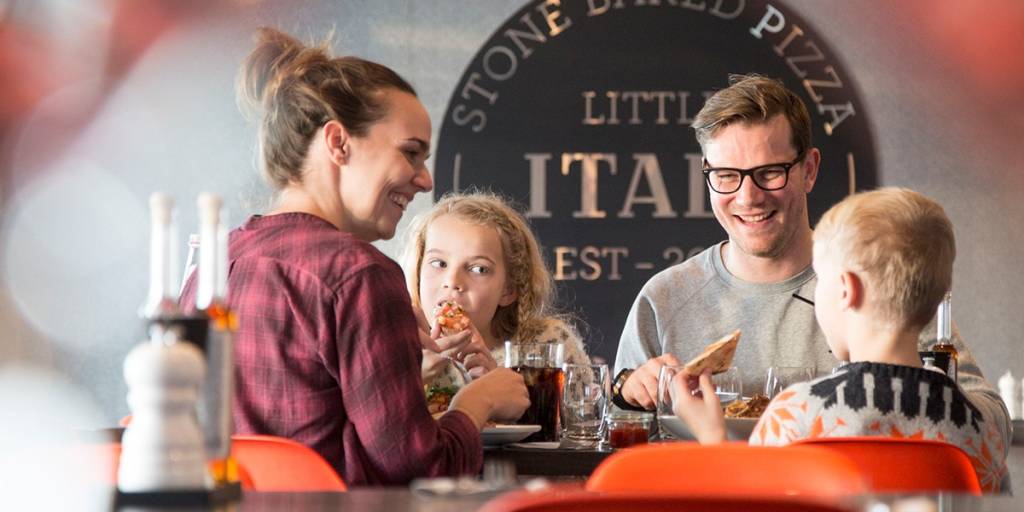 Familie spiser pizza i Little Italy