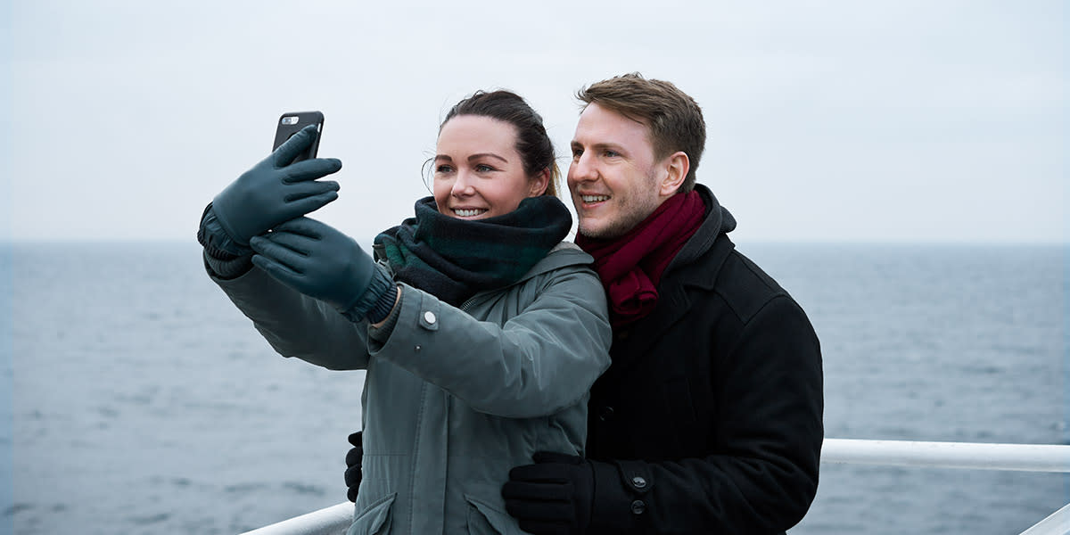 Couple on deck onboard DFDS ferry taking a selfie Couple on deck onboard minicuise