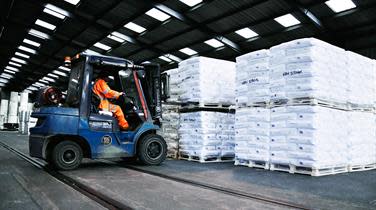 A forklift loading pallets of goods inside a DFDS warehouse