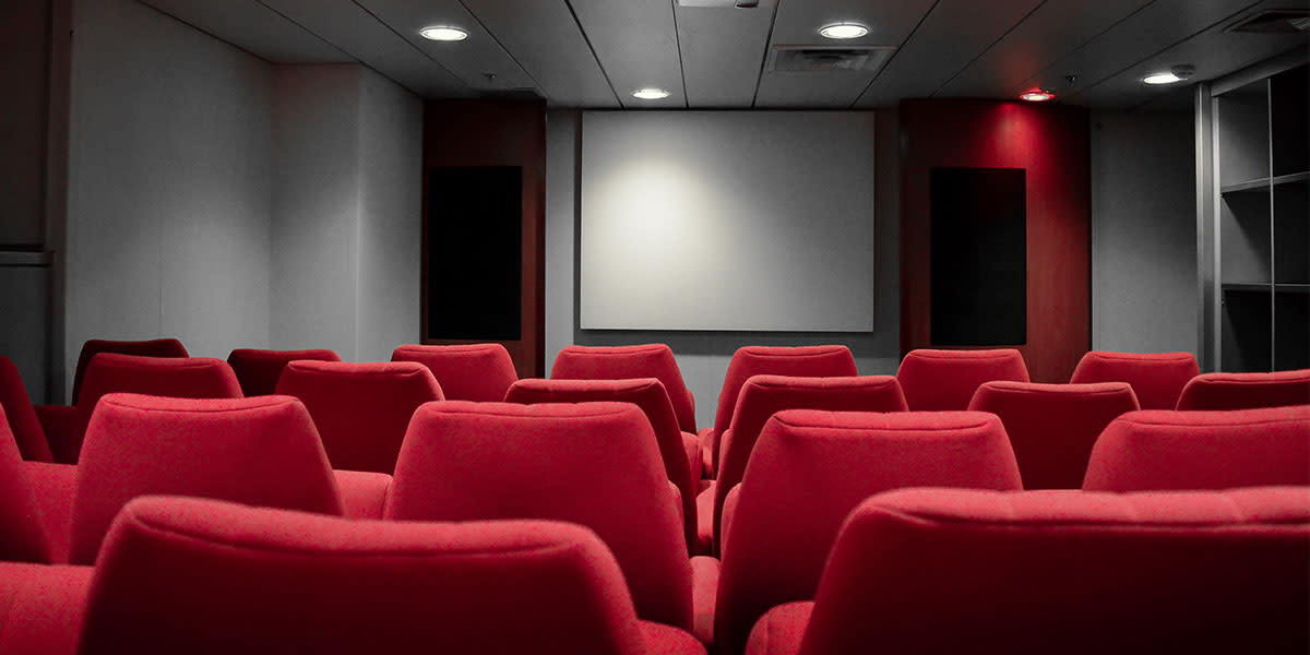 Czerwone fotele w sali kinowej
