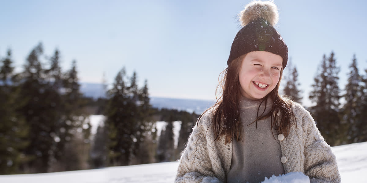 Girl smiling in the snow Hero