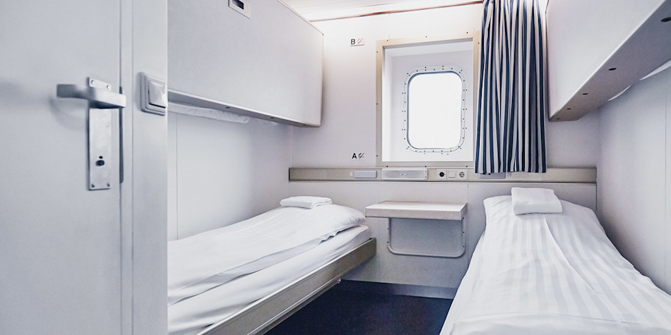 Two freshly-made single beds in a pet friendly cabin 