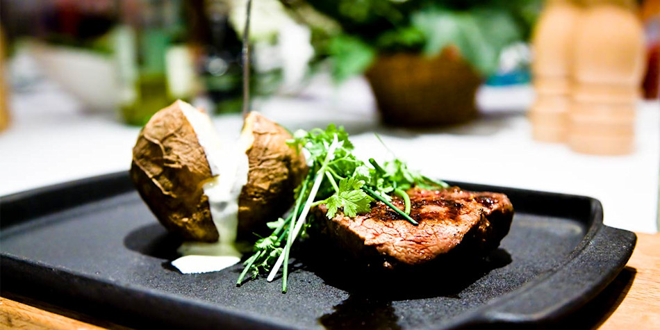 A steak and jacket potato ready to be served. 