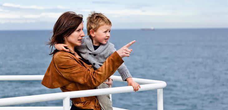 Matka z synem na rękach patrza na morze z pokładu promu
