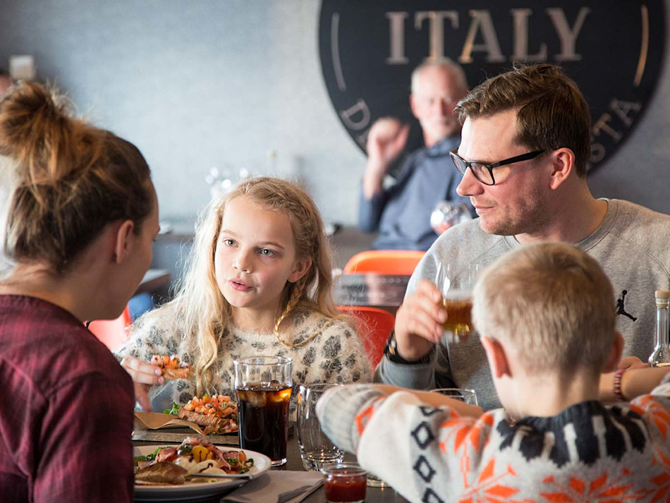A family dining at our onboard restaurant Little Italy