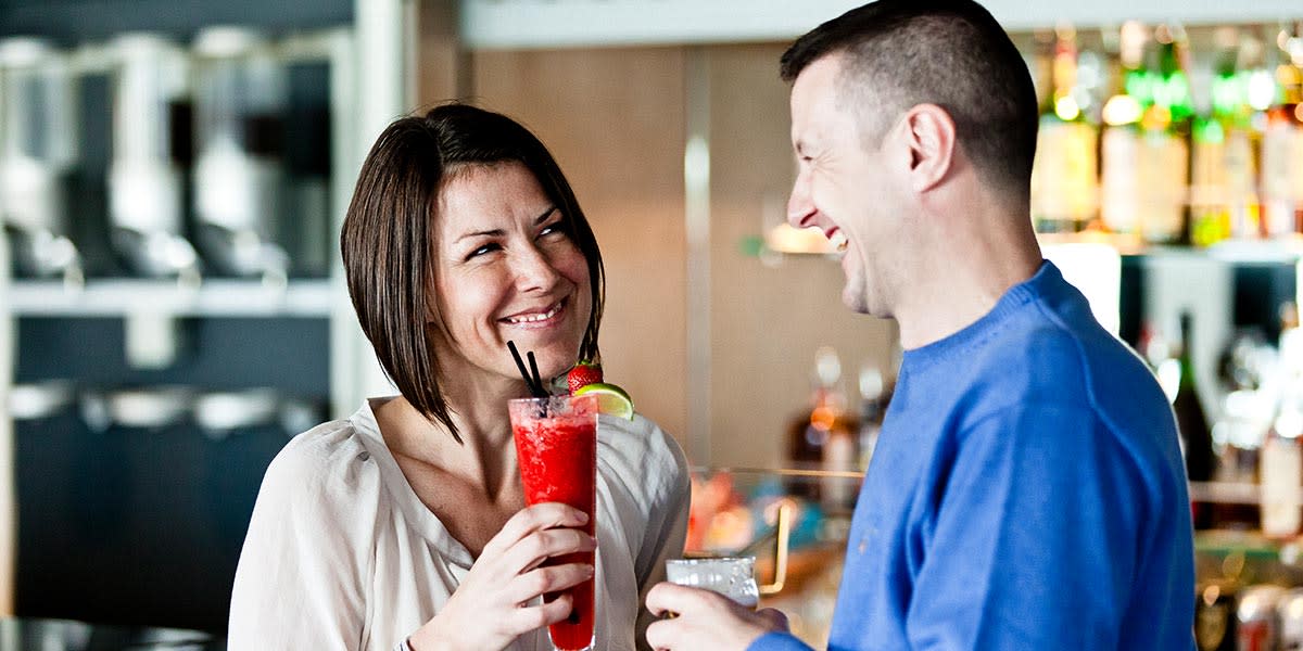 Kobieta i mężczyzna piją koktaile w barze