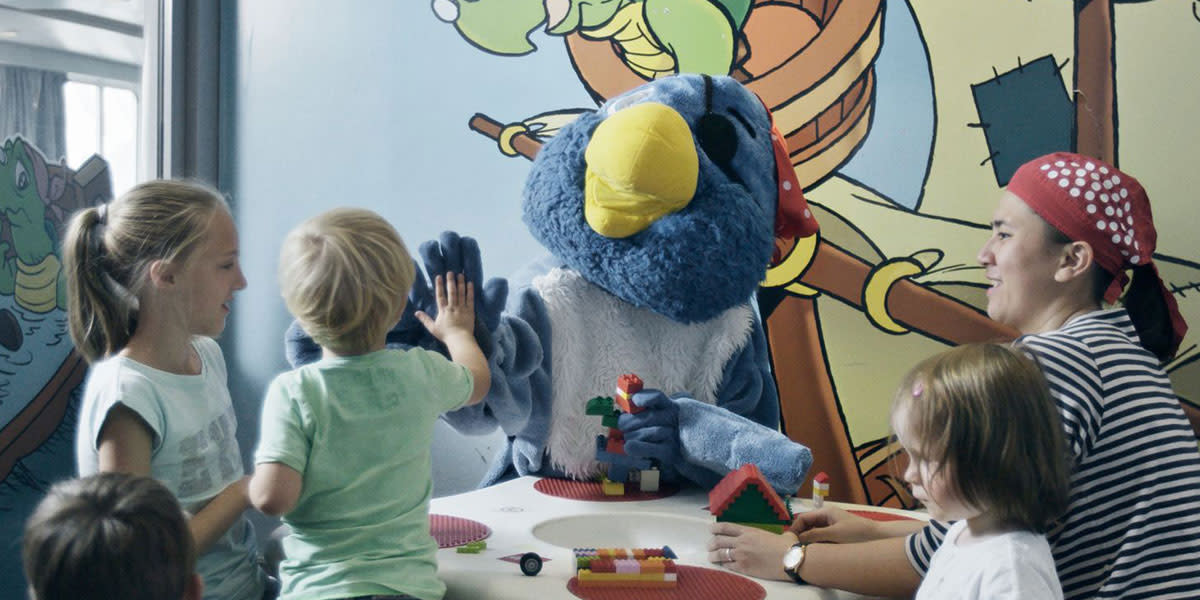 Maskotka papugi pirata bawi sie razem z grupką dzieci