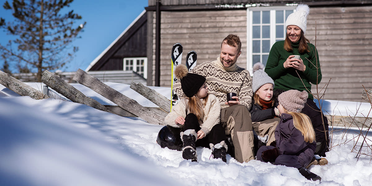 Familietid i sneen foran hytte i Norge - vinter Familietid i sneen foran hytte i Norge - vinter