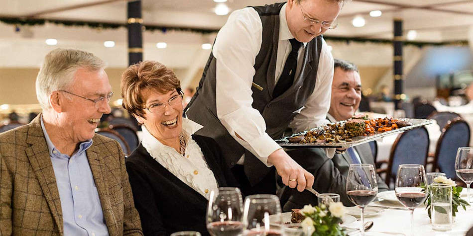 A group being served their food at the onboard Blue Riband restaurant
