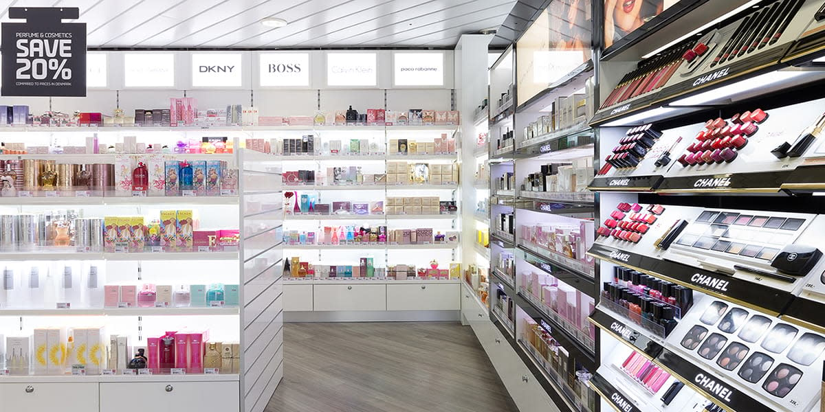 Regale mit Kosmetik und Parfum in duty free shop an Bord