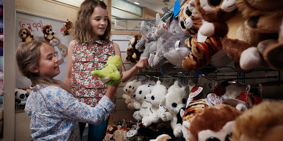 Two girls looking at stuffed animals in duty-free shopping area onboard Eastern Channel Ferry.