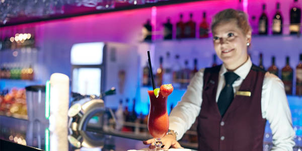 Kellnerin serviert einen Coctail in an Bord Bar
