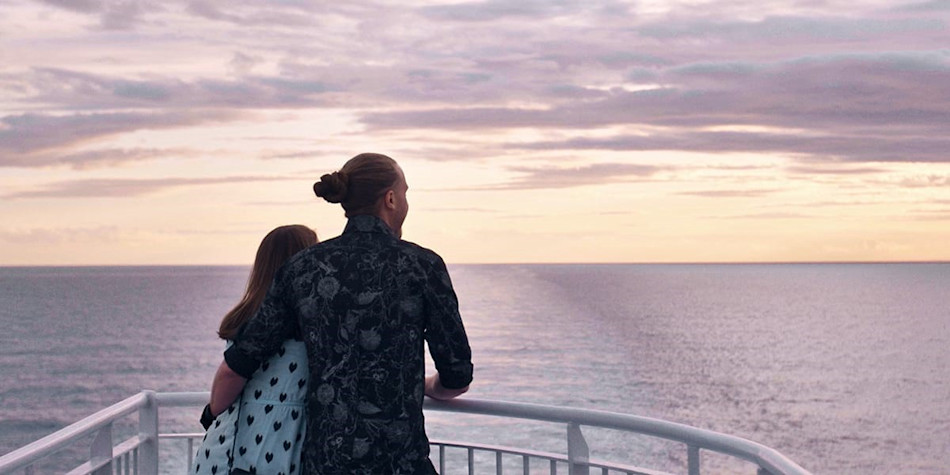 Couple on deck onboard DFDS ferry watching the sunset.