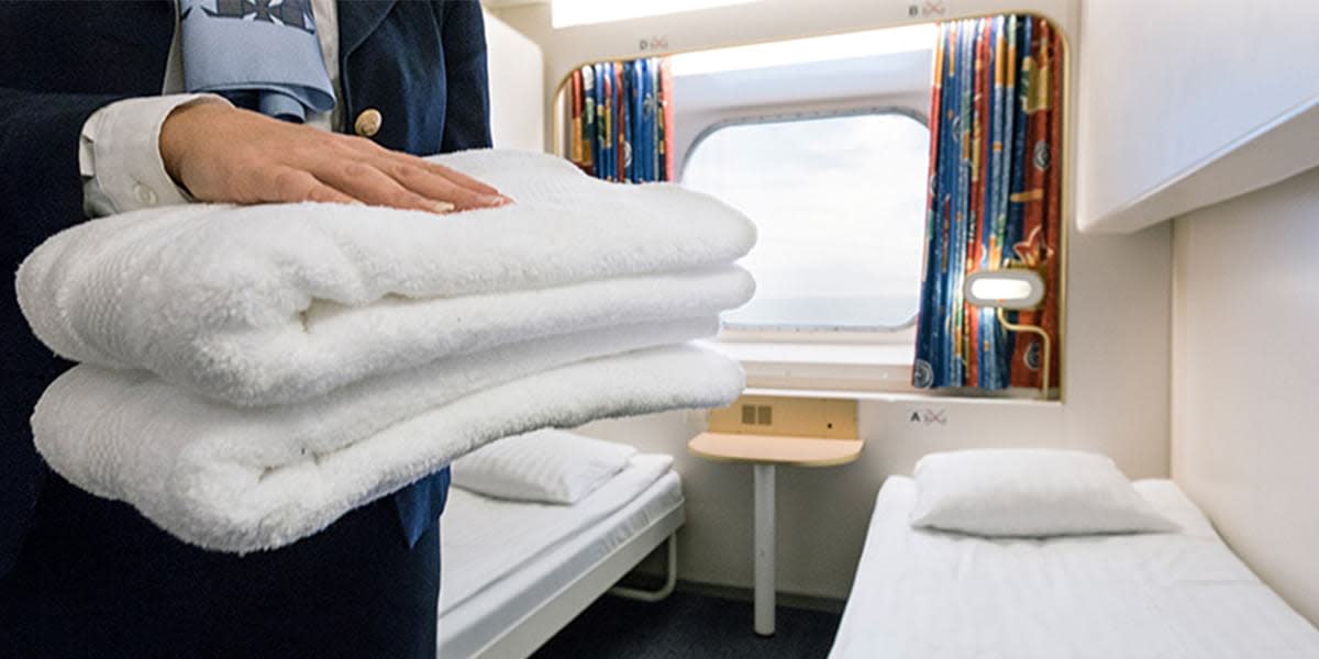 Obsługa promu kładzie świeże ręczniki na łóżko