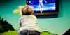 A little boy watching a cartoon television program in the kids club.