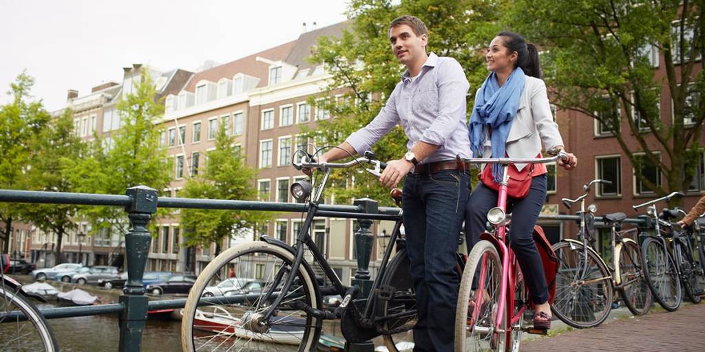Par på cykler ved kanalen i Amsterdam
