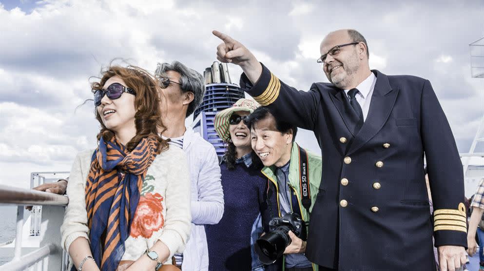 DFDS captain pointing out the sight to Asian tourists Asian-tourists-captain