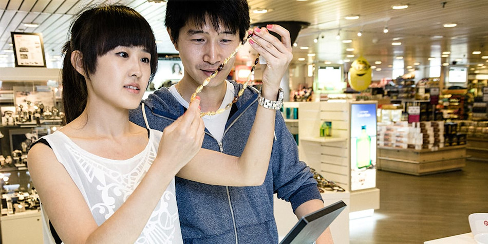 A couple looking at a necklace onboard the ferry