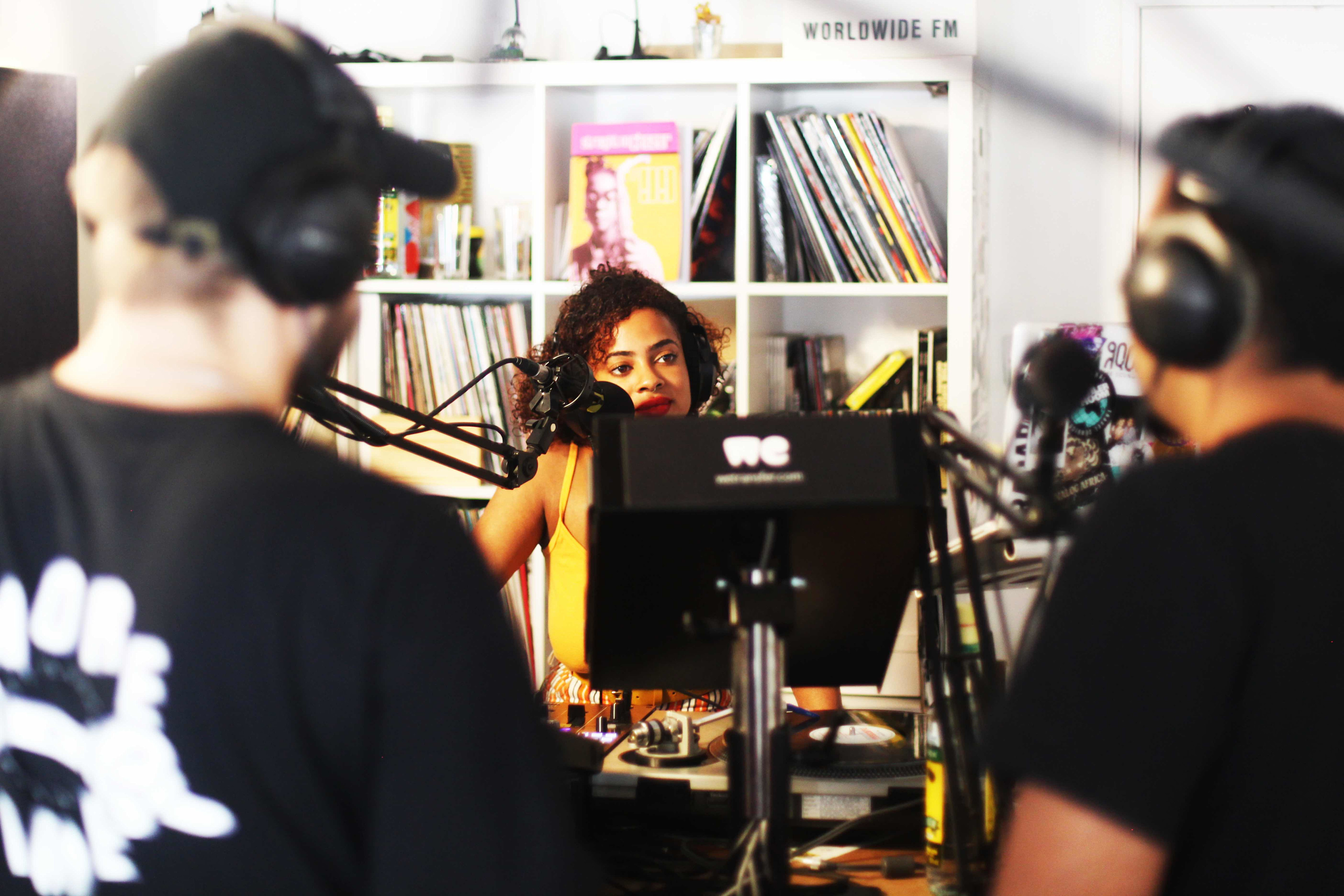 A female music artist being interviewed by two radio hosts in the Worldwide FM studio 