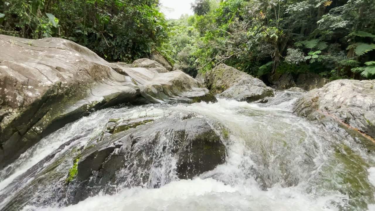 Agua que corre sobre grandes rocas en Las Paylas.