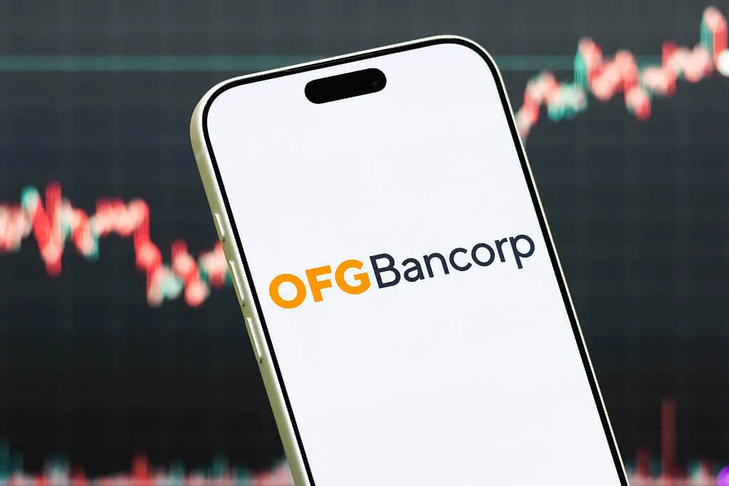 Celular mostrando el logo de OFG Bancorp con gráficas bursátiles de fondo en rojo y verde

Ilustración fotográfica de: Cheng Xin/Getty Images