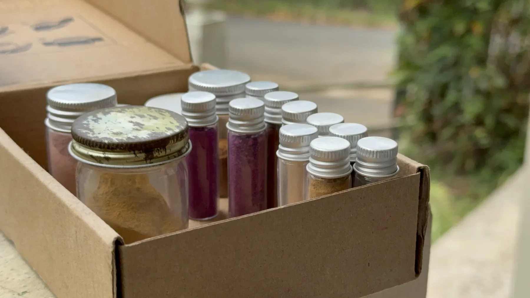 Caja con pequeños frascos de pigmentos naturales