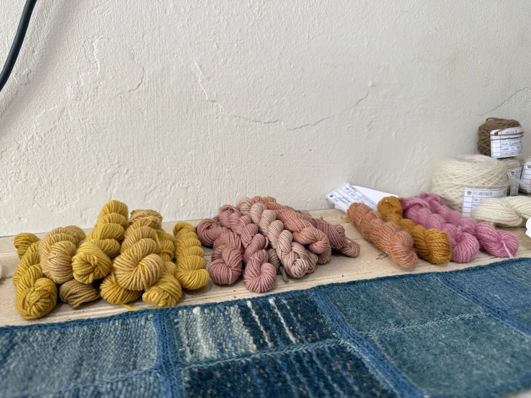 Madejas de hilo y pequeños frascos de pigmentos sobre una mesa