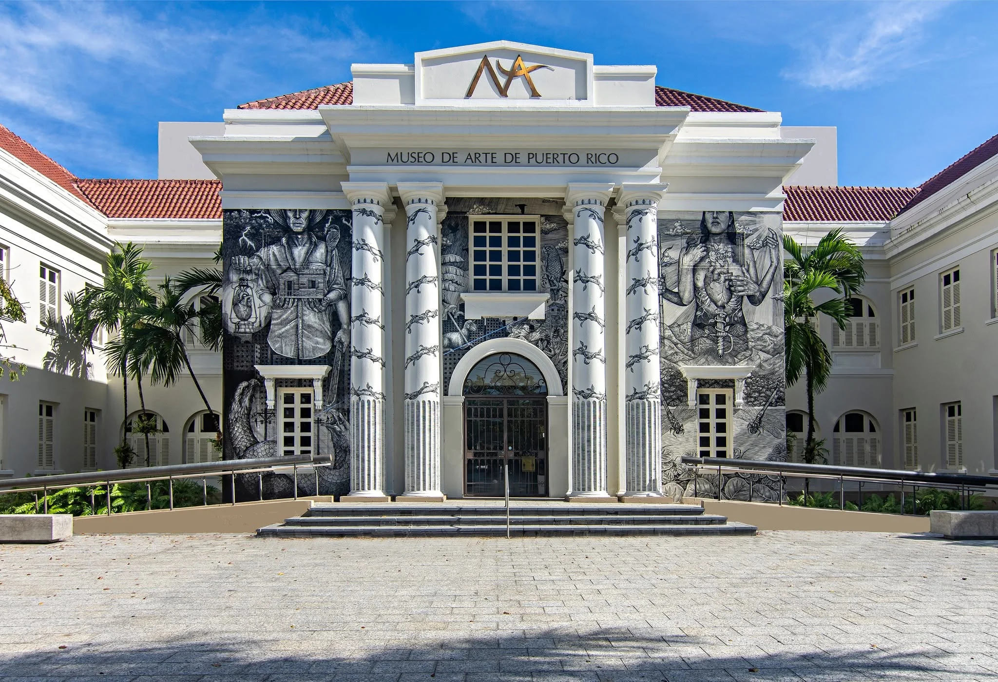 Fachada del Museo de Arte de Puerto Rico con columnas blancas, murales en blanco y negro, y palmas a los lados.

Foto vía Facebook: Museo de Arte de Puerto Rico 