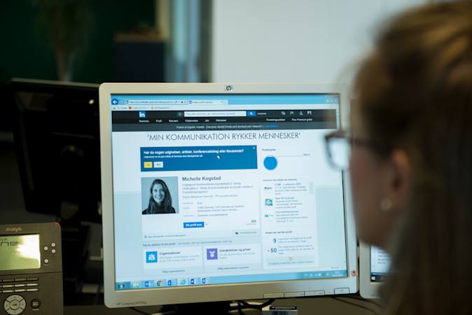 Person sidder foran computerskærm, hvorpå der vises en LinkedIn profil