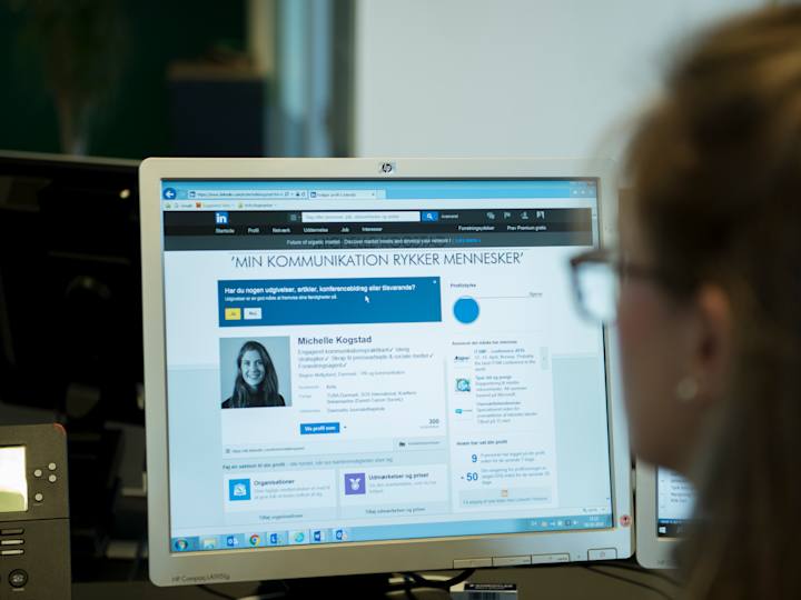 Person sidder foran computerskærm, hvorpå der vises en LinkedIn profil