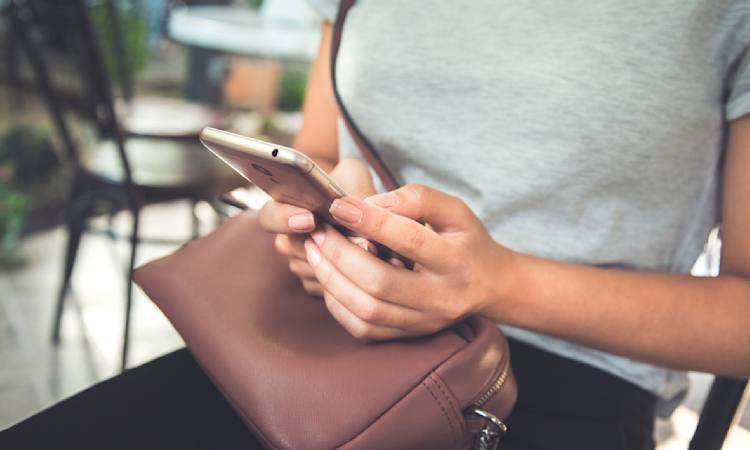 Person sidder og kigger på mobiltelefon efter en jobsamtale