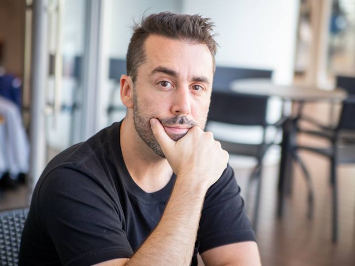 Mand sidder og tænker i cafeområde