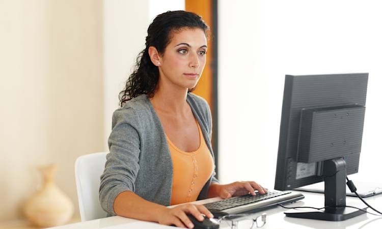 Foto af person, der sidder foran en computerskærm