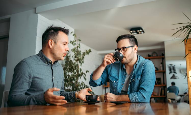 to mænd i samtale mens de drikker kaffe