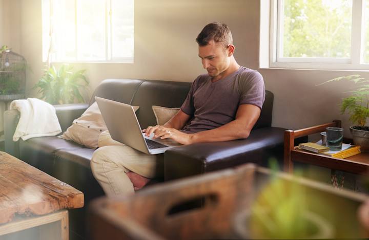 Person sidder med bærbar i sofaen og søger job