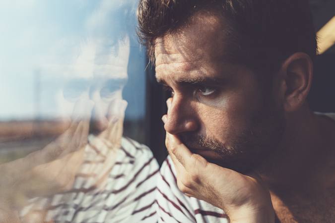 Stresset kvinde i sit køkken med et barn på armen