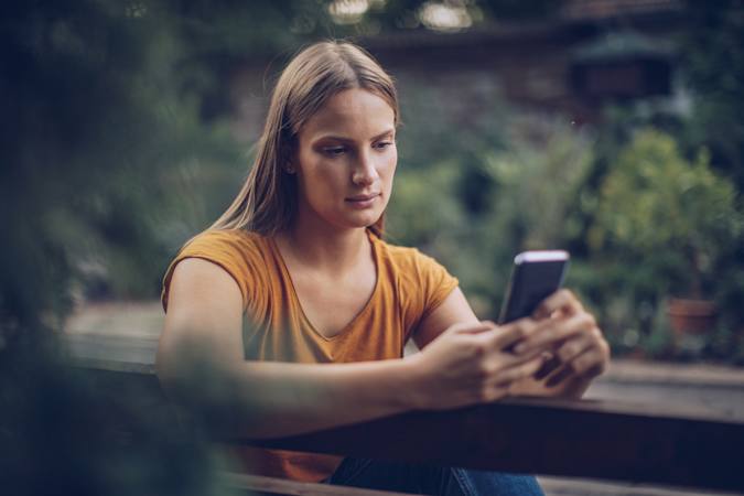 Person som er blvet opsagt sidder og kigger på sin telefon