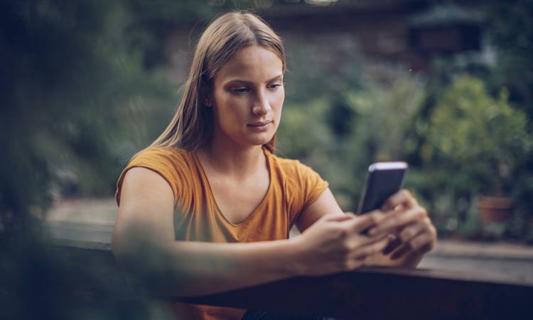 Person som er blvet opsagt sidder og kigger på sin telefon