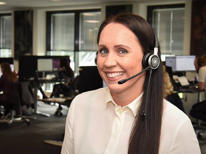 Krifa-ansat der sidder og snakker i telefon med medlem
