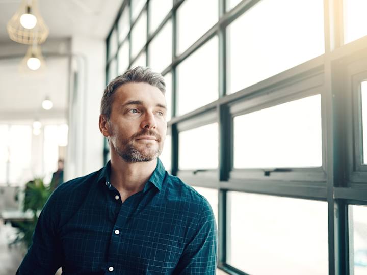 Person kigger ud af vindue på arbejdsplads