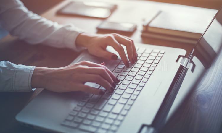 Person sidder ved computer og søger efter job på nettet