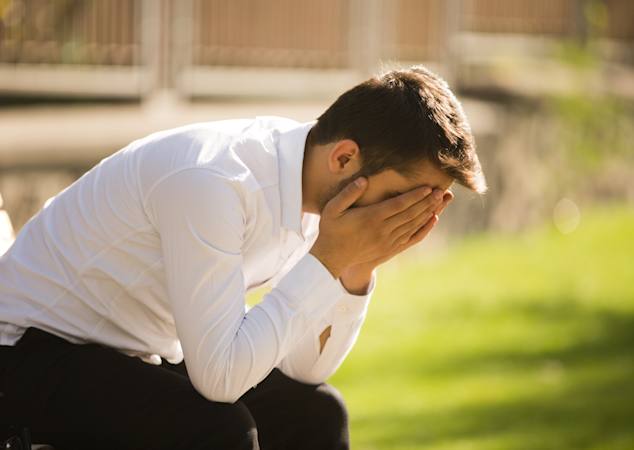 Person sidder med hovedet begravet i hænderne 