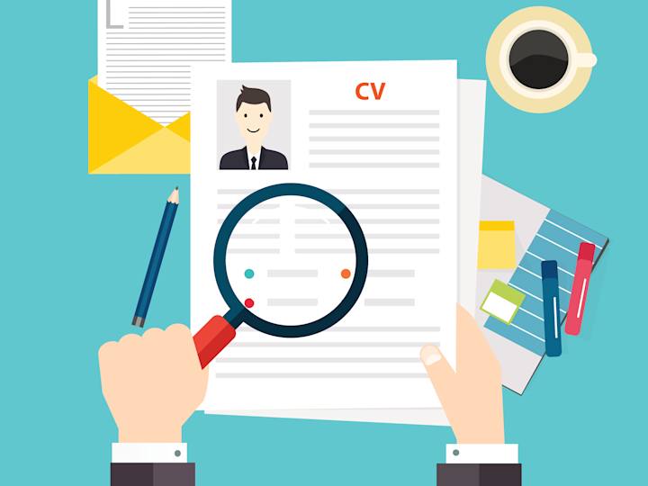 Person kigger på CV med lup