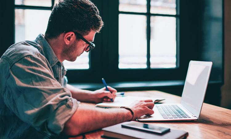 Person sidder ved computer og arbejder med CV-layout