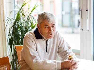Ældre mand sidder på arbejdsplads