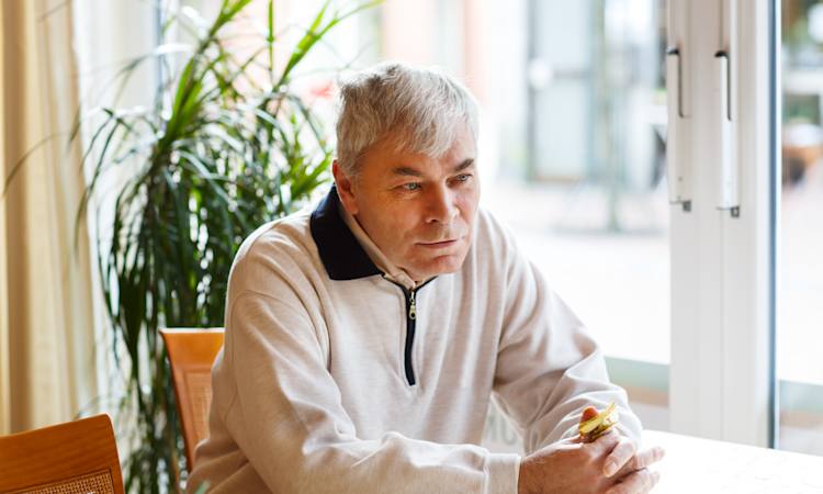 Ældre mand sidder på arbejdsplads