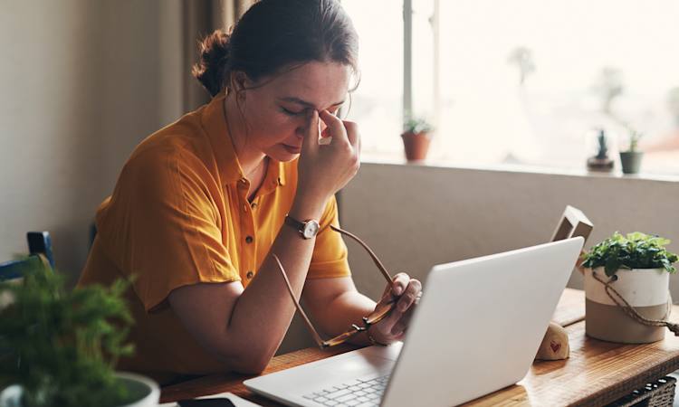 Ledig person sidder ved computer og ser stresset ud